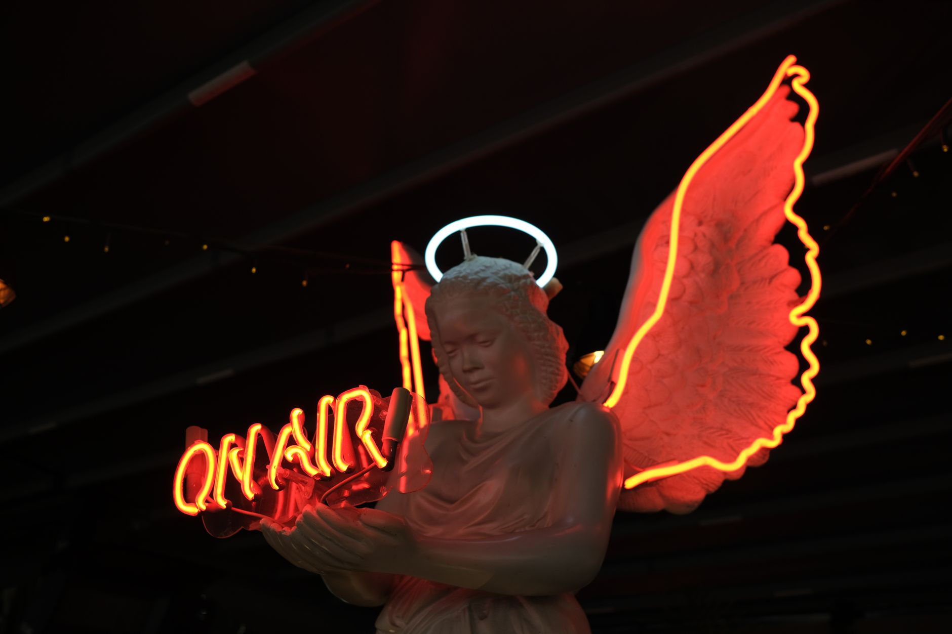 angel statue with on air sign illuminated at night