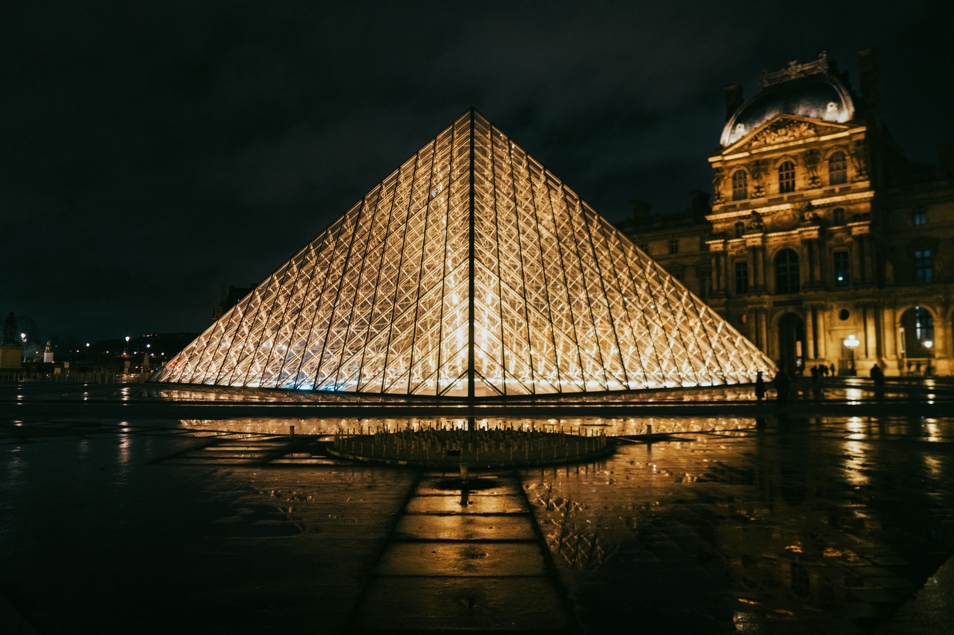 louvre pyramid illuminated at night in paris